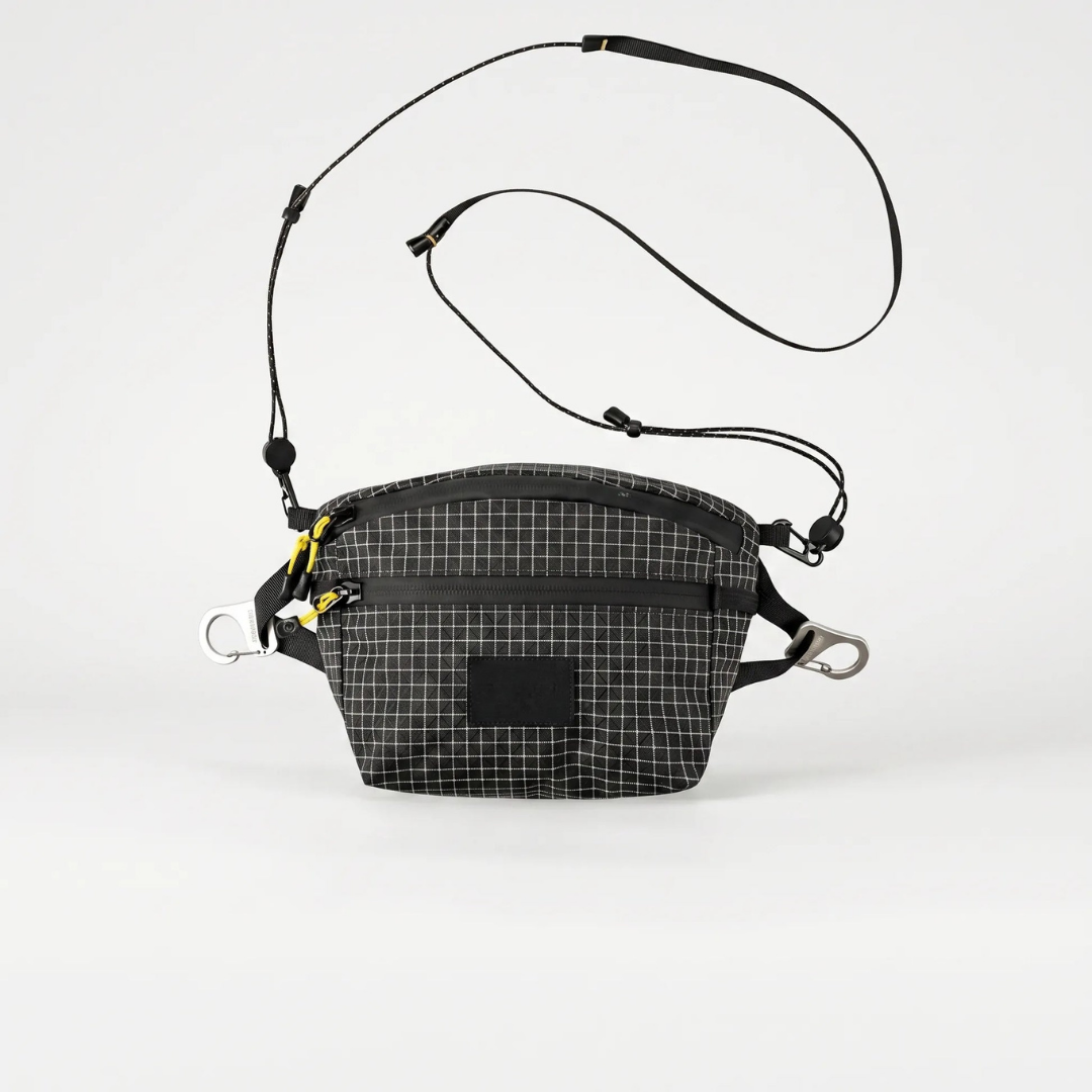 Saszetka biodrowa męska szara noszona jako crossbody – widok z boku