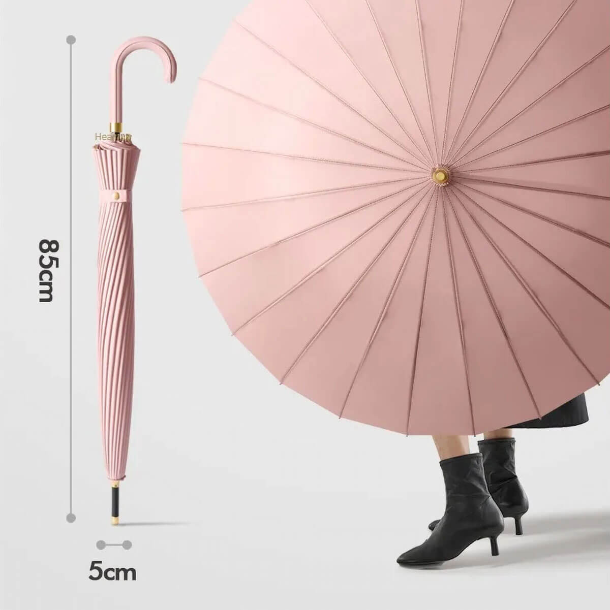 Różowy parasol damski długi oparty obok torebki – porównanie rozmiarów