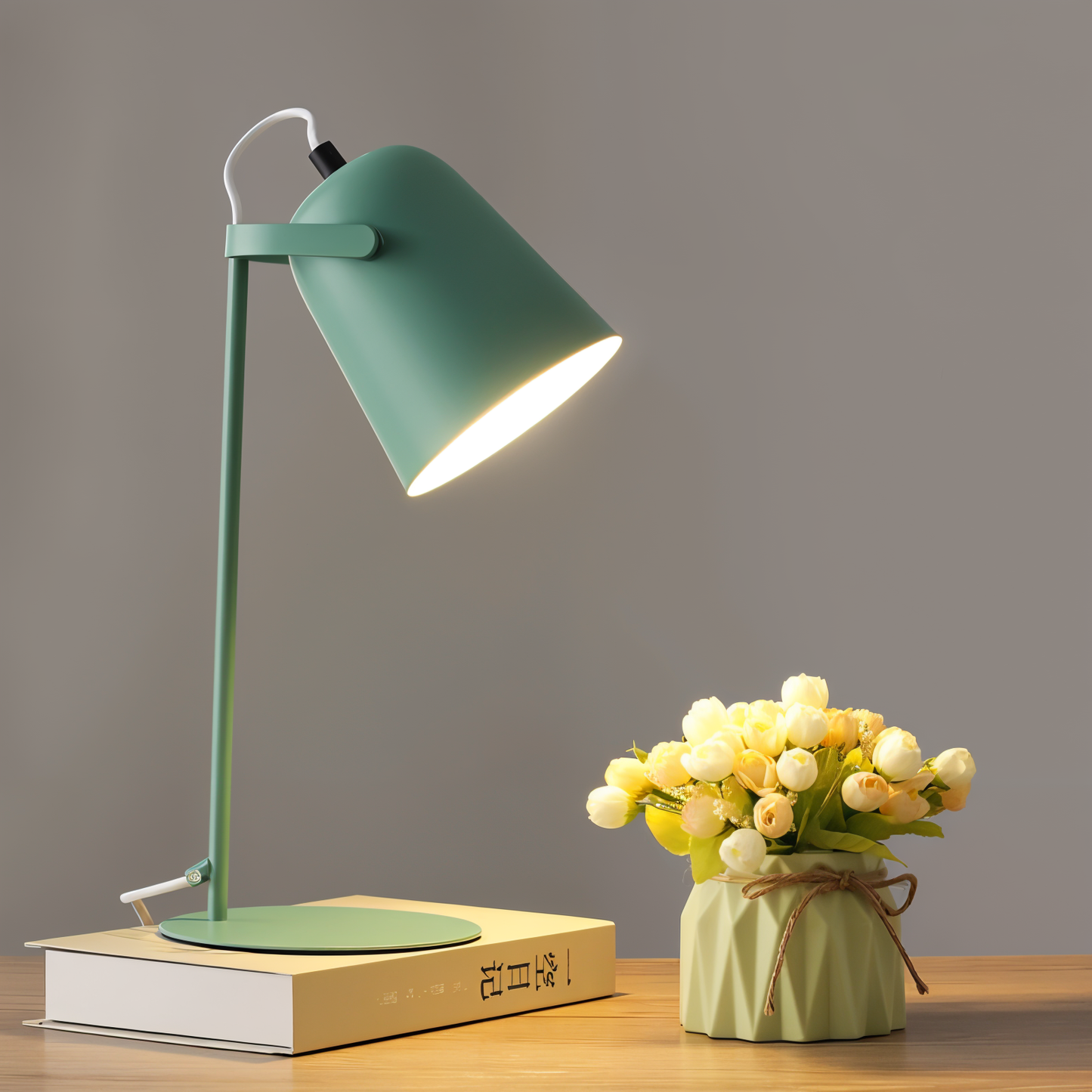 Elegancka lampa stołowa LED w zielonym kolorze obok wazonu z kwiatami.