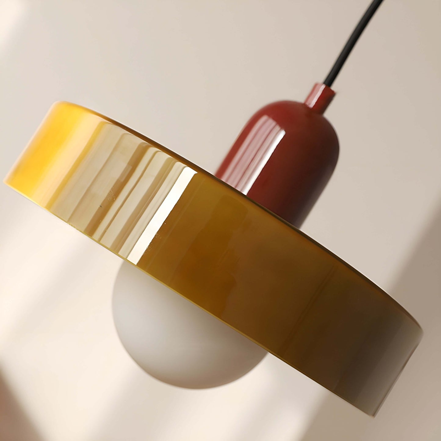 Nowoczesna szklana lampa wisząca w kolorze żółtym i czerwonym z minimalistycznym designem.