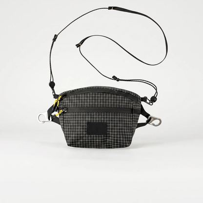 Saszetka biodrowa męska szara noszona jako crossbody – widok z boku