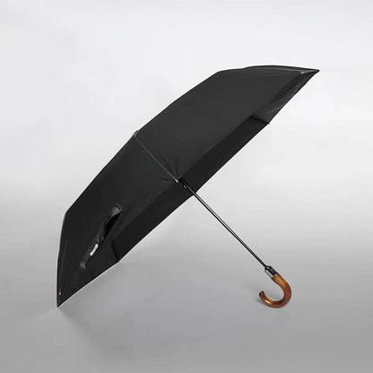 Osoba trzymająca duży parasol składany z wygodną drewnianą rączką